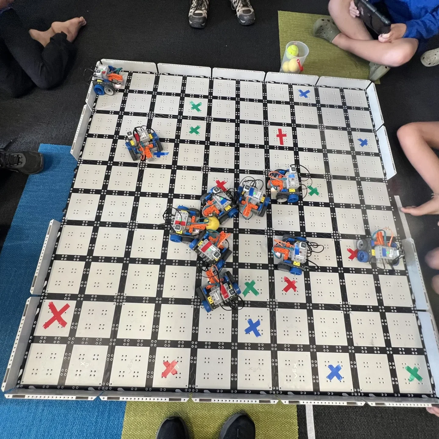 Children operating robots on large grid board